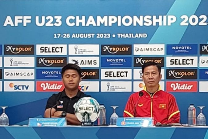 AFF U23 챔피언십 2023 기자회견에서 공식 경기 공이 놓인 탁자 앞에 선 감독과 선수